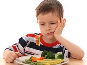 5-6 years old boy and plate of cooked vegetables isolated on white